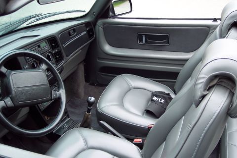 2001 Ford Crown Victoria - Interior of a Saab 900 convertible, gray leather seats and dashboard details. A WRX cap rests on the passenger seat.