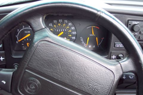 2001 Ford Crown Victoria - The interior of a 1992 Saab 900 Turbo Convertible is visible, the steering wheel and instrument cluster with gauges.
