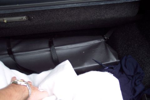 2001 Ford Crown Victoria - The contents of a car's trunk are shown, including a black bag and some blankets.