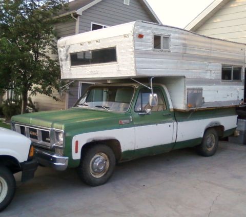 2006 Ford E350 - This GMC pickup truck is equipped with a camper shell, suggesting it's set up for travel or outdoor living.