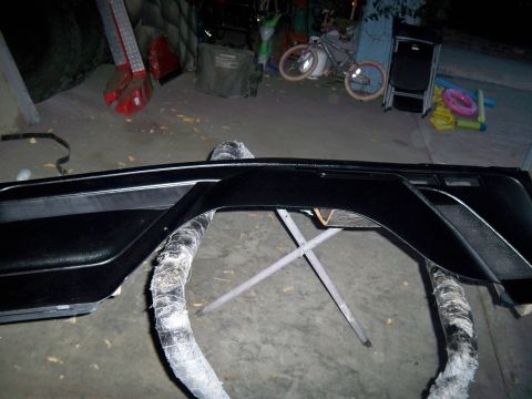 1985 Ford Bronco - Black car door panel with chrome trim is shown on sawhorses.