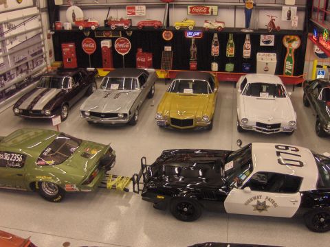 1970 Chevrolet Camaro - Multiple vintage cars, including a 1970 Chevrolet Camaro police car, displayed with memorabilia.