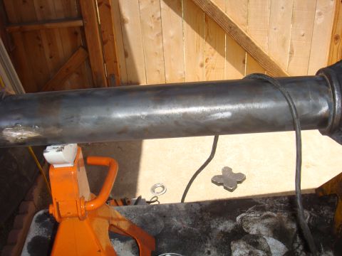 1992 Ford Bronco - A drive shaft is shown supported by a jack stand in a garage setting.