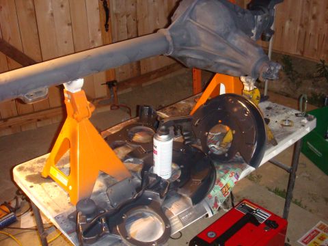 1992 Ford Bronco - Vehicle axle and brake components are laid out on a table for maintenance or painting.