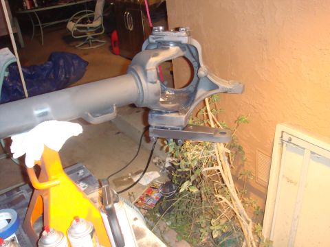 1992 Ford Bronco - A close-up view of a vehicle's axle assembly, resting on a jack stand with various tools nearby.