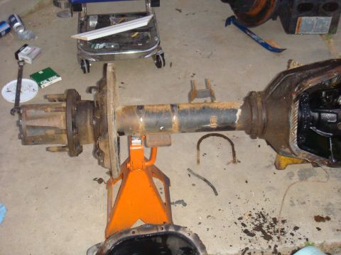 1992 Ford Bronco - A disassembled vehicle axle assembly is shown on jack stands in a garage setting.