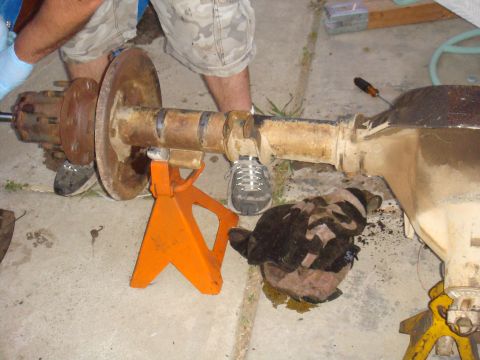 1992 Ford Bronco - Axle assembly being worked on, supported by jack stands. Supermotors.net logo in corner.
