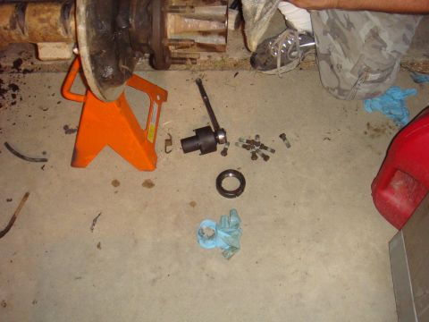 1992 Ford Bronco - Tools and parts are laid out on the floor for vehicle axle repair.