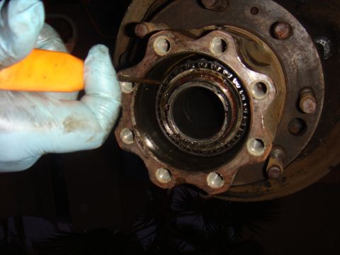 1992 Ford Bronco - Close-up of a vehicle hub assembly being serviced with a tool.