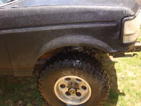 1992 Ford Bronco - Close-up view of the fender and large off-road tire on a black 1992 Ford Bronco.