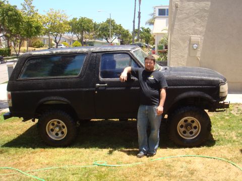 1992 Ford Bronco - A man poses with a black 1992 Ford Bronco, which appears to be modified for off-road use.