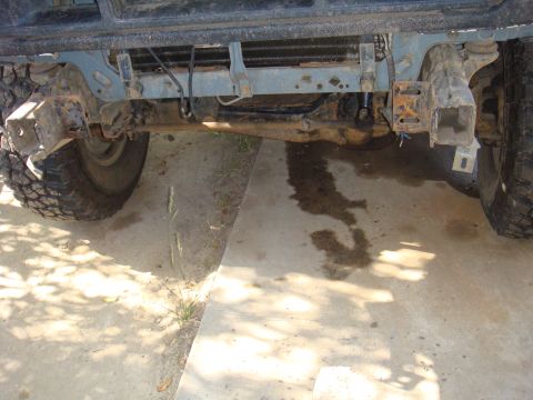 1992 Ford Bronco - Close-up view of the front axle and suspension components of a vehicle, showing large off-road tires.