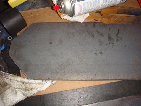 1992 Ford Bronco - Metal part on a workbench with a spray can and rags nearby.