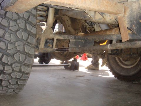 1992 Ford Bronco - The underside of a vehicle is shown, focusing on the suspension and drivetrain components.