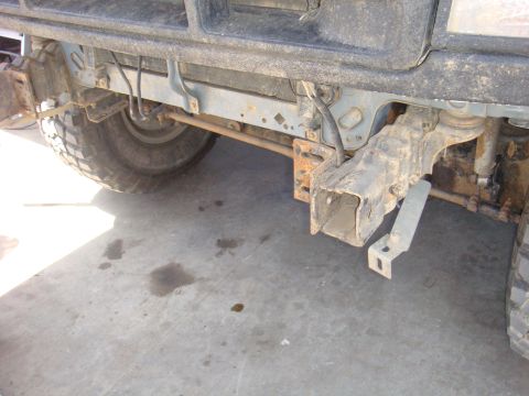 1992 Ford Bronco - Close-up of vehicle's front axle and suspension parts, with a tire on the left.