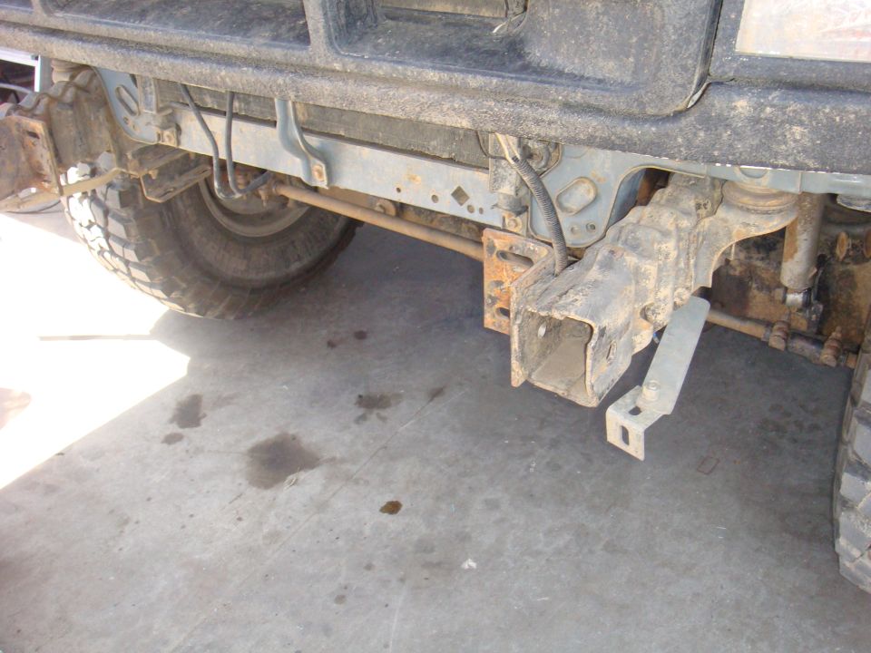 Front axle, suspension, and frame components of a vehicle, with a tire visible on the left