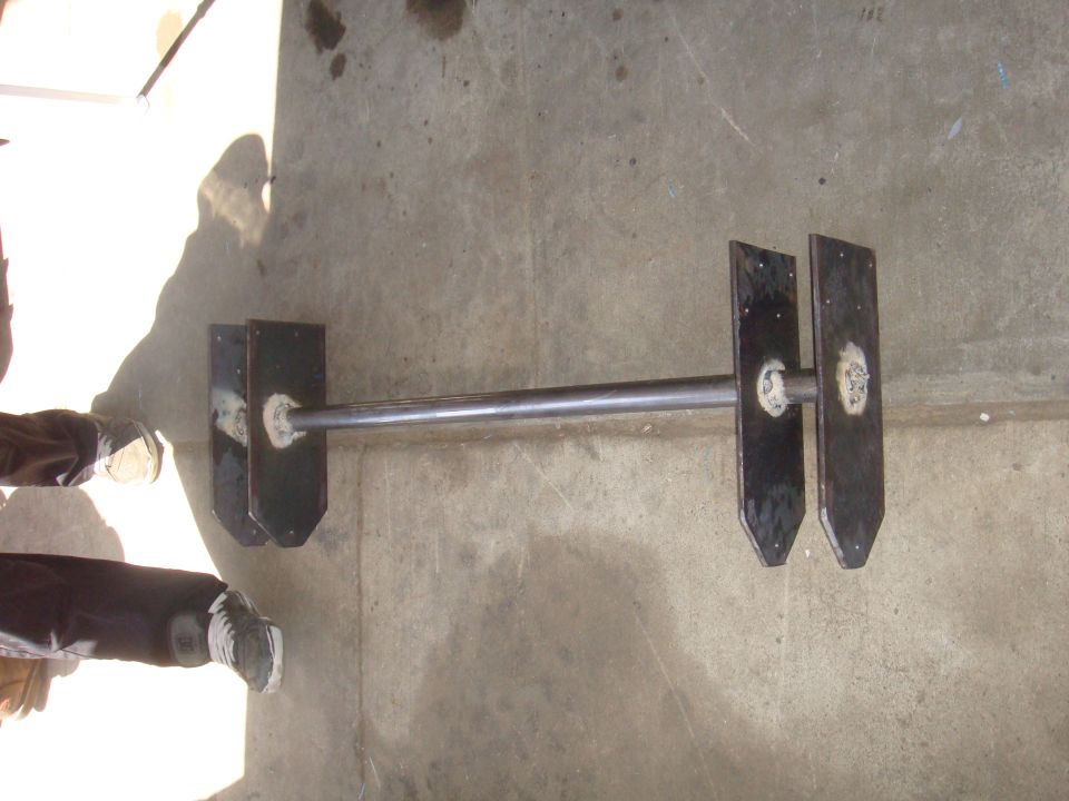 homemade axle assembly with two plates welded to each end of a metal bar