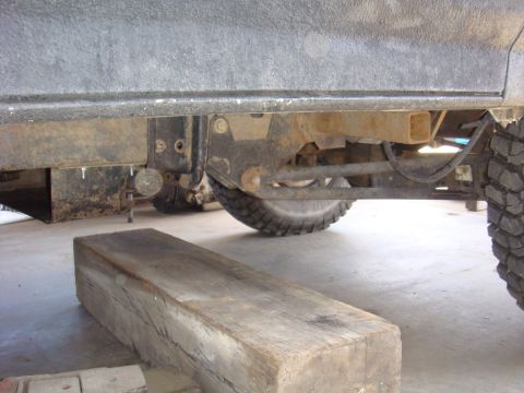 1992 Ford Bronco - Vehicle undercarriage and suspension components are visible, with a wooden block placed nearby.