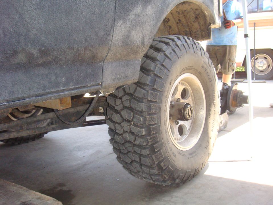 Close-up of a large off-road tire and rear axle assembly on a vehicle