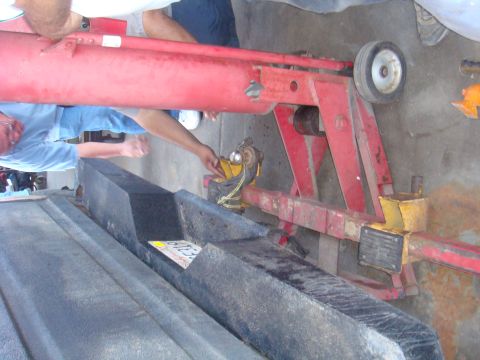 1992 Ford Bronco - Red vehicle lift equipment is shown with yellow accents and a wheel, suggesting it is part of a repair or maintenance process.