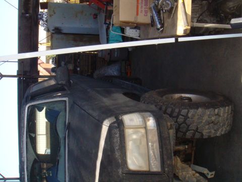 1992 Ford Bronco - 1992 Ford Bronco parked in a garage with various items in the background.