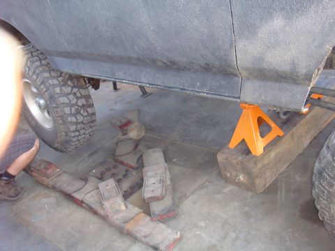 1992 Ford Bronco - Vehicle frame and suspension parts are visible while the vehicle is supported by jack stands.