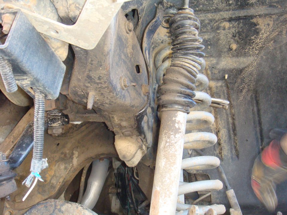 Front suspension components with a rubber boot and coil spring