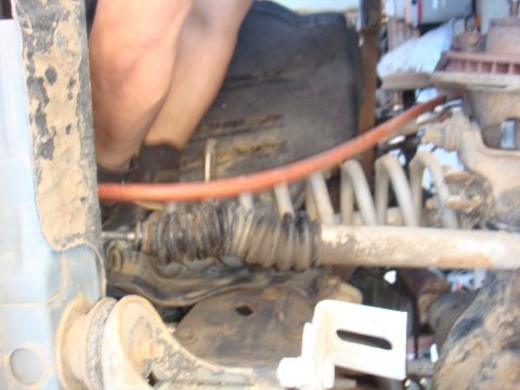 1992 Ford Bronco - Mechanic's hands visible working on vehicle suspension system components.