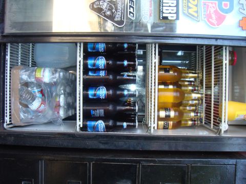 1992 Ford Bronco - A refrigerator is filled with bottles of Bud Light, other beers, and water bottles.