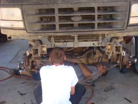 1992 Ford Bronco - Mechanics work on the front axle of a 1992 Ford Bronco.