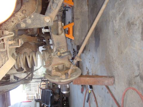 1992 Ford Bronco - Close-up view of a vehicle's front axle and suspension system, likely undergoing maintenance.