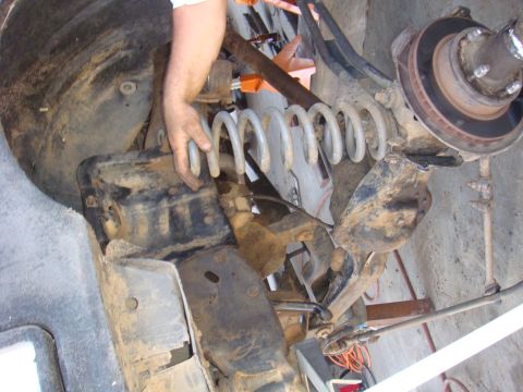 1992 Ford Bronco - Close-up view of the front suspension and axle assembly, showing the coil spring and brake components.
