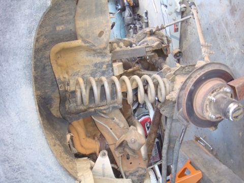1992 Ford Bronco - Close-up of vehicle front suspension and axle parts, likely during a repair or build.