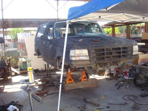1992 Ford Bronco - Front end of a 1992 Ford Bronco undergoing repairs in a workshop.