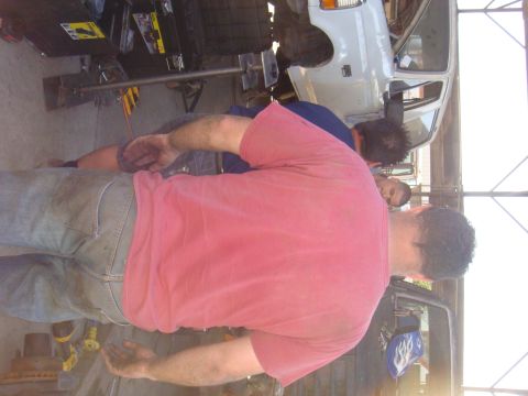 1992 Ford Bronco - Two mechanics are working on a white 1992 Ford Bronco in a garage.