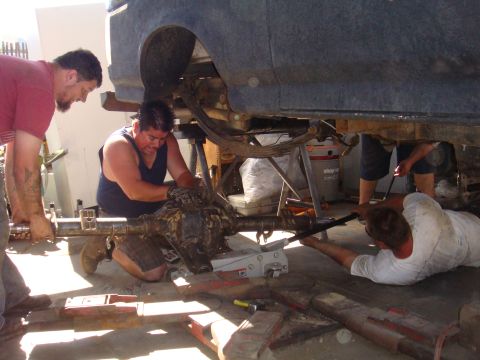 1992 Ford Bronco - Mechanics are shown working on the rear axle of a vehicle, likely during a repair or modification.