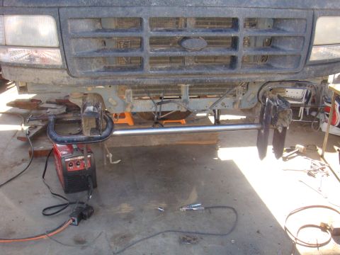 1992 Ford Bronco - Front end of a 1992 Ford Bronco being worked on, with welding equipment nearby.