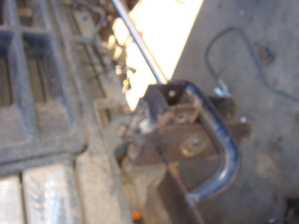 Close-up of a metal bracket and some plastic trim inside a vehicle