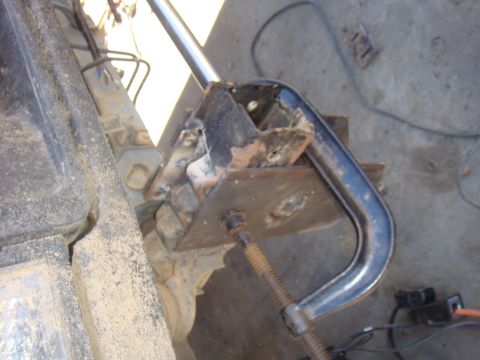 1992 Ford Bronco - A C-clamp is used to secure a damaged metal bracket on a vehicle's suspension system.