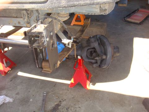 1992 Ford Bronco - Vehicle axle and suspension components are elevated on jack stands for maintenance or repair.