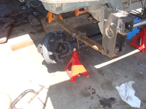 1992 Ford Bronco - The rear axle and suspension of a vehicle are elevated on jack stands for repair work.