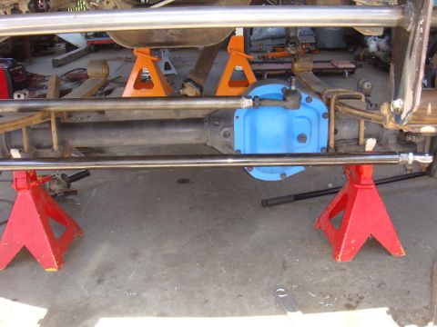 1992 Ford Bronco - Close-up view of a vehicle's axle assembly, supported by red and orange jack stands, a blue differential cover.