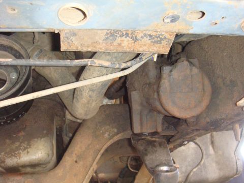 1992 Ford Bronco - Close-up view of the rusty undercarriage and mechanical components of a vehicle.