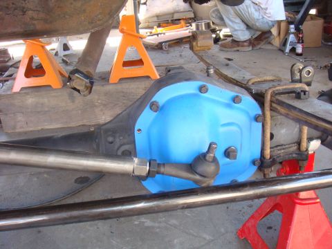 1992 Ford Bronco - A rear axle assembly with a bright blue differential cover is shown, supported by jack stands.