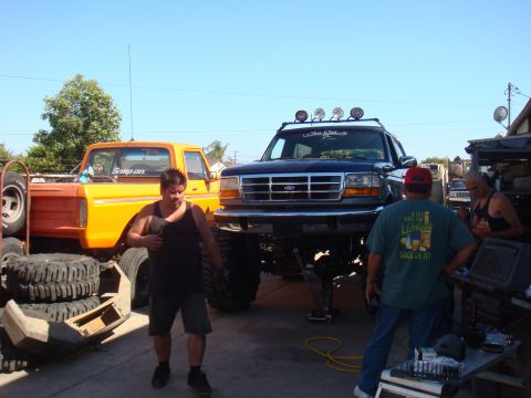1992 Ford Bronco - A lifted 1992 Ford Bronco is worked on in a garage setting, with another truck visible.
