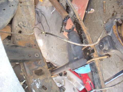 1992 Ford Bronco - Close-up view of vehicle frame and suspension components, showing signs of rust and wear.