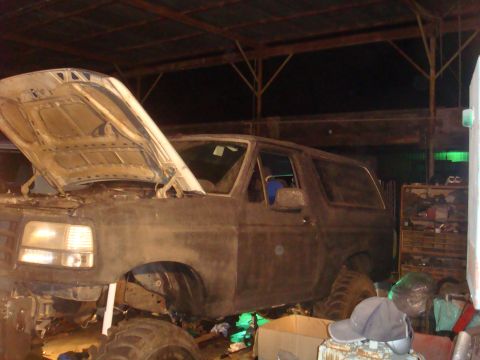 1992 Ford Bronco - This 1992 Ford Bronco is in a garage with its hood up, suggesting it is undergoing maintenance or modification.