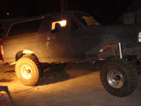 1992 Ford Bronco - This dark SUV features a lifted suspension and oversized tires, suggesting modifications for off-road use.