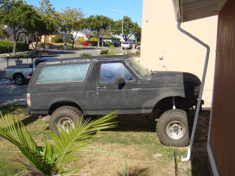 1992 Ford Bronco - Side view of a modified 1992 Ford Bronco with a lifted suspension and large tires.