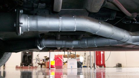 1973 Ford Ranchero - The underside of a vehicle shows newly installed dual exhaust pipes with visible welds.